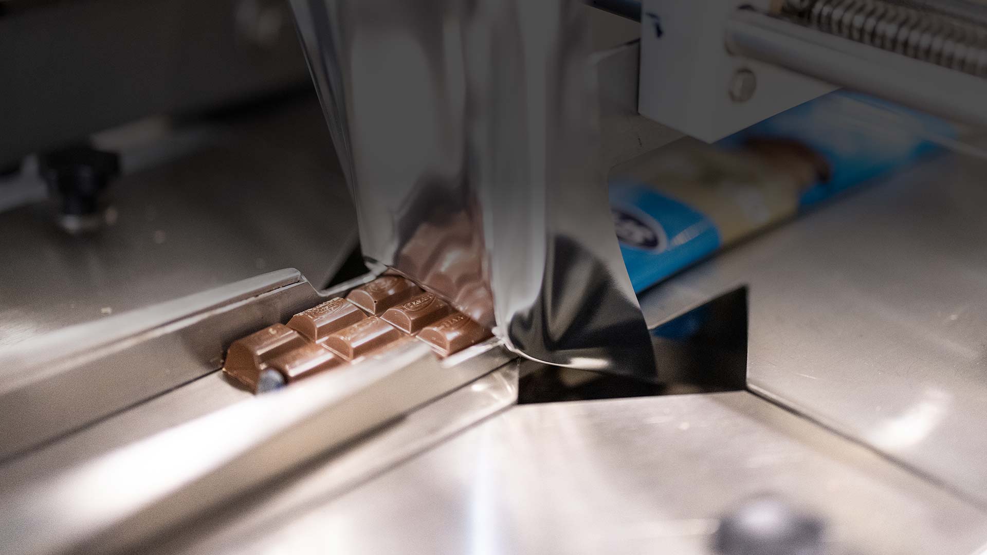 tableta de chocolate siendo embalada por máquina